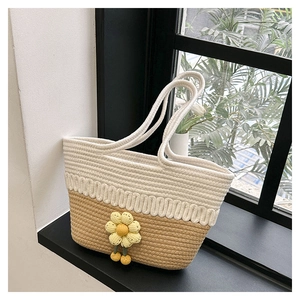 Detail of hollow woven cotton tote with yellow sunflower charm and bicolor textured patterns