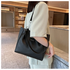 Détail d'un grand sac cabas en cuir noir avec étiquette fashion et anneaux en métal