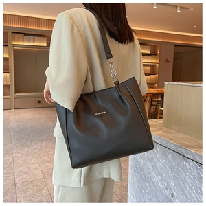 Détail du sac cabas noir avec bandoulière en chaîne argentée et lettrage de mode chic
