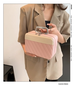 Detail of pink and beige quilted makeup bag with wide silver metal handle and zipper