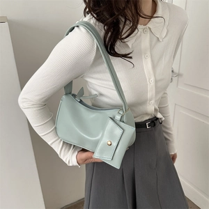 Chic mint green hobo shoulder bag set with matching mini chain pouch on a female model