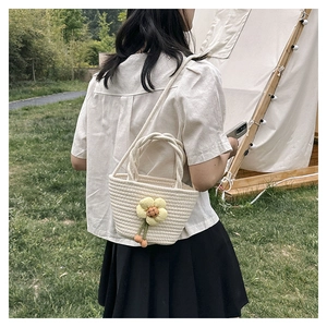 White woven bucket bag with sunflower detail shown in a summer outdoor camping scene