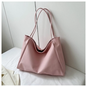 Detail of light pink tote bag featuring magnetic closure and durable shoulder straps