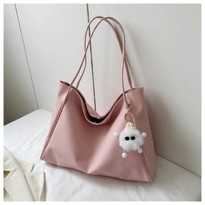 Detail of soft pink large tote bag with cute plush pendant and slim shoulder straps