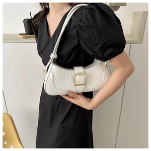 Détail du sac baguette blanc avec texture crocodile et boucle carrée dorée élégante