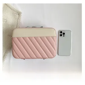 Detailed size comparison of pink quilted cosmetic bag next to a white smartphone