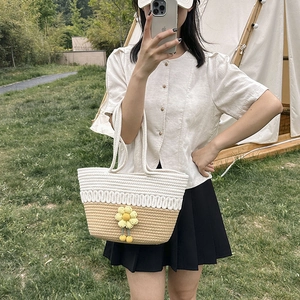 Summer woven tote bag in white and brown with yellow flower detail on outdoor grass