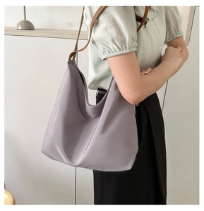 Detail of lavender oxford tote bag with contrast brown leather straps on model shoulder