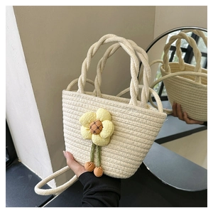 Detail of handwoven straw bucket bag with sunflower decor reflected in a circular mirror