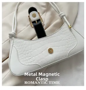 Détail du sac blanc à motif crocodile avec fermoir magnétique en métal doré élégant