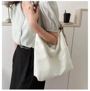 Detail of white nylon hobo bag with contrast brown adjustable leather shoulder strap