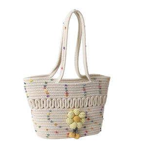 Cream hollow woven cotton shoulder bag with colorful pompoms and yellow flower charm