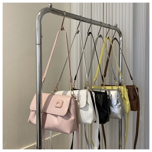 Détail montrant divers coloris de sacs à bandoulière plissés suspendus sur un présentoir