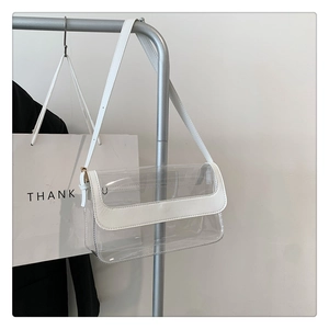 Détail du sac à bandoulière transparent en PVC avec bordure en cuir blanc et boucles
