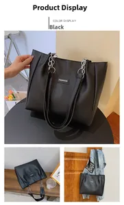 Détail du grand sac cabas noir avec bandoulière en chaîne argentée et logo FASHION