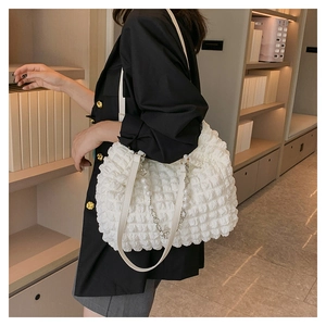 White popcorn fabric tote bag with elegant pearl and metal chain detail on model