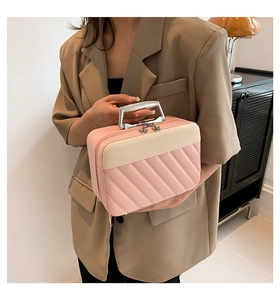 Pink and cream quilted makeup bag featuring silver U-shaped handle and floral zipper pulls