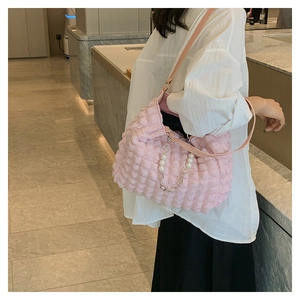 Detail of pink bubble texture tote bag with elegant pearl chain and soft leather strap