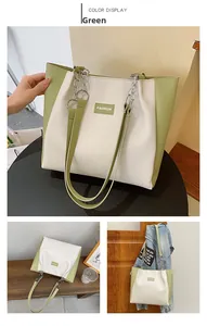 Détail d'un sac cabas bicolore crème et vert avec étiquette mode et bandoulière chaîne