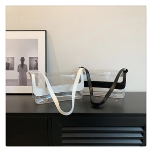 Détail de sacs bandoulière en PVC transparent avec bordures en cuir noir et blanc et rabat