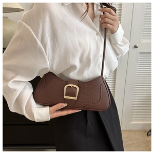 Détail du sac baguette marron foncé effet crocodile avec grande boucle dorée