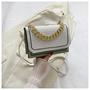Close-up of color-block crossbody bag with green leather and white woven flap