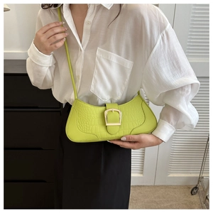 Détail du sac baguette vert fluo à texture crocodile avec boucle en métal doré