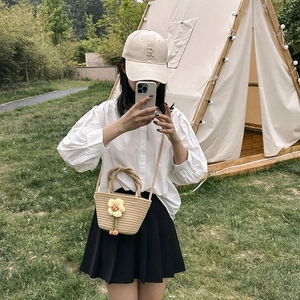 Handmade beige straw bucket bag with sunflower decor and crossbody strap for beach outings