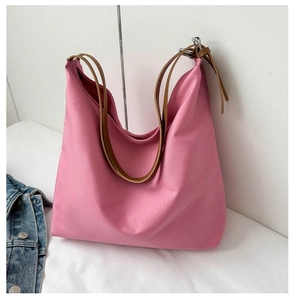 Detail of pink Oxford fabric tote bag featuring brown shoulder strap and silver buckle