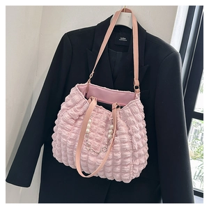 Detail of pink bubble texture tote bag featuring pearl and silver flower chain decor