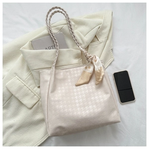 Beige tote bag with houndstooth texture, woven handles, and decorative floral scarf detail