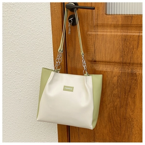 Détail du sac cabas mode avec poignée en chaîne métallique et bandoulière en cuir uni