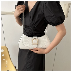 Détail du sac sous l'aisselle blanc à motif crocodile avec boucle en métal doré