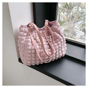 Detail of pink bubble texture tote bag with elegant pearl pendant and leather handle