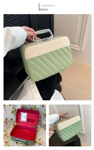Quilted cosmetic bag with metal handle, interior mirror and makeup brush slots