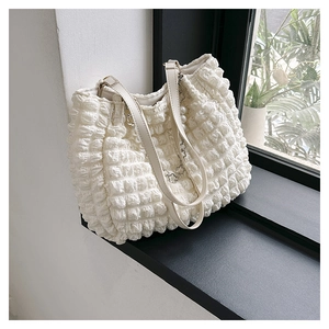 Detail of white bubble pleated tote bag with pearl charms and silver flower pendant