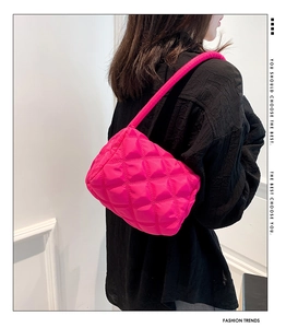 Detailed view of magenta quilted nylon puffer bag with diamond stitching texture
