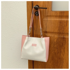 Détail du sac cabas patchwork rose et beige avec chaîne en métal et étiquette fashion