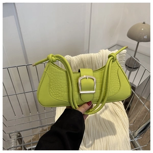 Détail du sac baguette vert vif avec texture crocodile et boucle en métal argenté