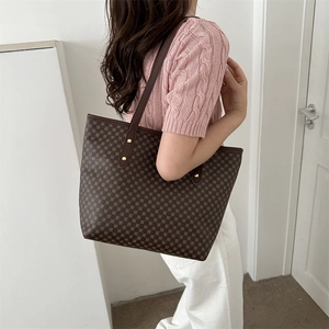 Fashionable brown geometric pattern large tote bag worn on a shoulder by a model