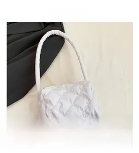 Detailed view of the white quilted nylon bag with intricate diamond stitching and textures