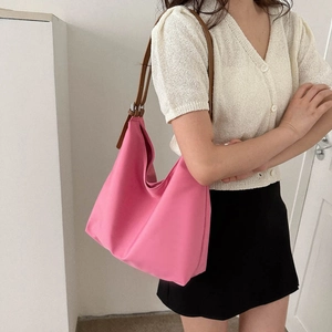 Pink large capacity Oxford cloth tote bag with brown leather strap worn by a model