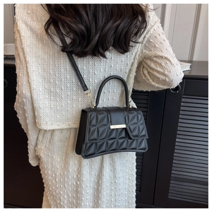 Dettaglio della borsa in pelle PU nera trapuntata con finiture metalliche oro