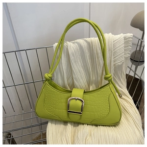 Détail du sac sous l'aisselle vert en similicuir avec motif croco et boucle d'or