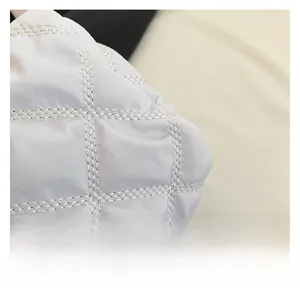 Close-up of white quilted nylon fabric with classic diamond stitching and soft texture