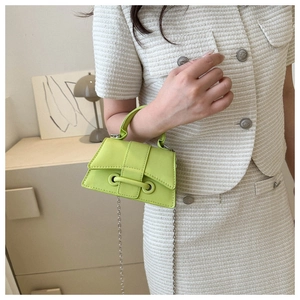 Lime green mini crossbody bag with silver chain strap shown on beige knit outfit