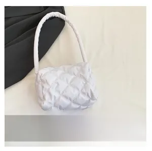 Detailed comparison showing white quilted nylon bag size next to a smartphone