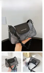 Detail of grey denim and black leather patchwork bag with metallic chain and woven handle