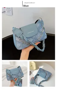 Detail view of blue faux denim patchwork handbag with flower chain and woven handle