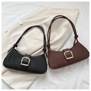 Détail de sacs baguette gaufrés croco avec boucles dorées et bandoulières nouées